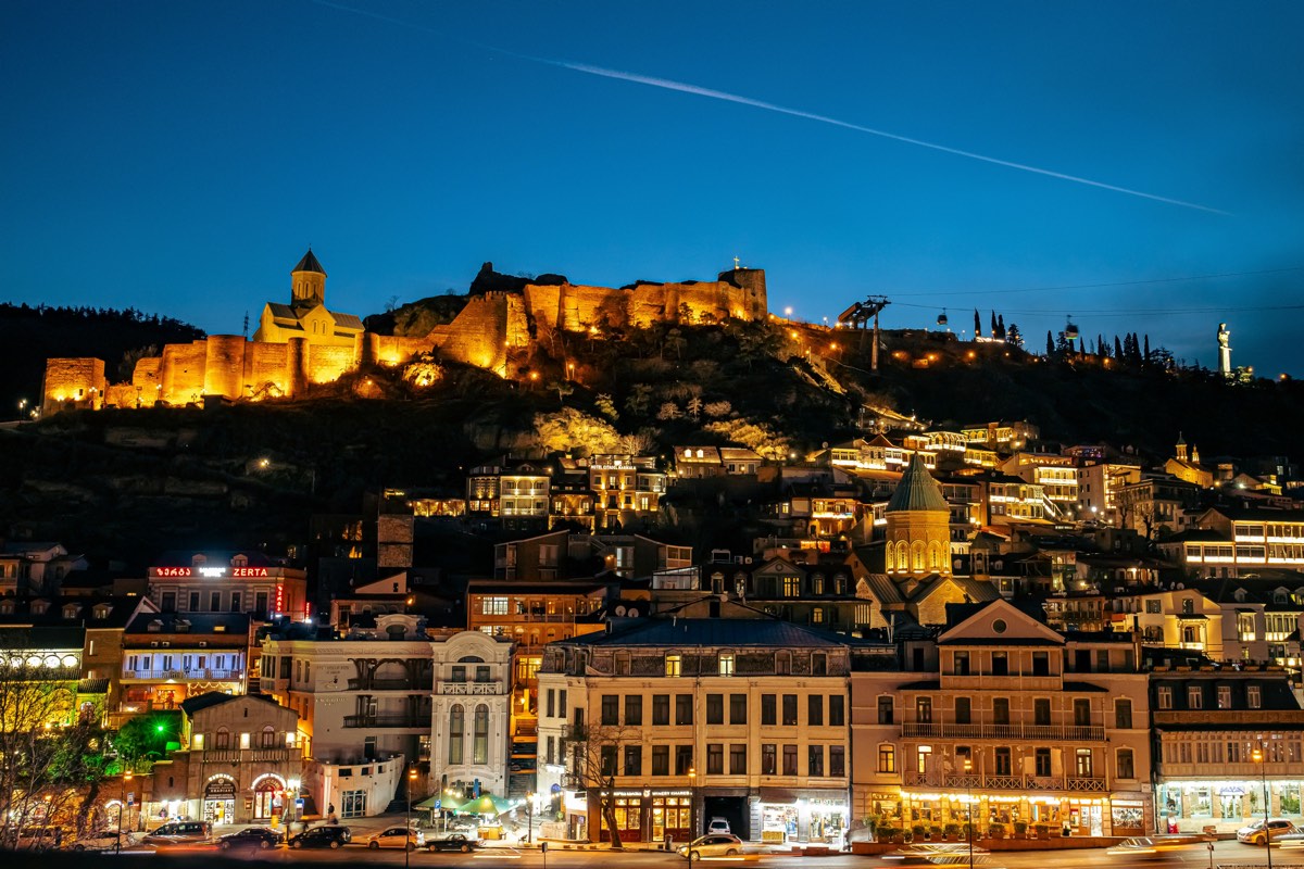 Narikala Fortress lit up above Old Tbilisi at dusk, Georgia